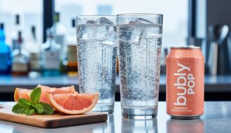 Close-up of grapefruit-flavored bubble sparkling water in a tall glass with visible carbonation, grapefruit slices, mint leaves, and a chilled mini can on a bar counter.