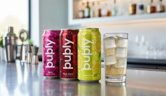 Chilled bubly POP cans and a clear highball glass with sparkling bubbles on a modern bar counter.